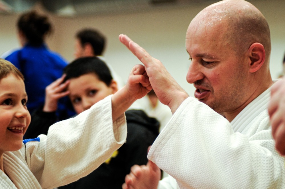 Sensei ukazuje dětem techniku na tréninku juda
